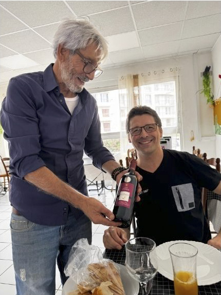 Jaoudat présentant une bouteille à Olivier Pastor dans la salle du restaurant El Maza à Perpignan